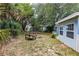 Tranquil backyard features lush trees and an outdoor seating area at 22275 Belinda Ave, Port Charlotte, FL 33952