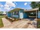 Charming blue home with a cozy front porch and convenient covered carport at 22275 Belinda Ave, Port Charlotte, FL 33952