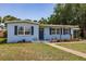 Charming light blue single-story home featuring mature landscaping and a walkway to the front door at 22275 Belinda Ave, Port Charlotte, FL 33952