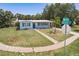 Charming home featuring a manicured lawn and a welcoming blue front door at 22275 Belinda Ave, Port Charlotte, FL 33952