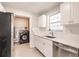 Bright kitchen features white cabinets, stainless steel appliances, and laundry hookups in adjacent room at 22275 Belinda Ave, Port Charlotte, FL 33952