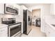 Modern kitchen with stainless steel appliances, including oven, microwave and refrigerator, and laundry hookups in adjacent room at 22275 Belinda Ave, Port Charlotte, FL 33952
