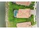 Aerial view of a home with a pool, lush landscaping, and a serene lake backdrop at 235 River Enclave Ct, Bradenton, FL 34212
