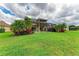 Spacious backyard featuring a screened lanai, lush greenery, and vibrant tropical plants at 235 River Enclave Ct, Bradenton, FL 34212