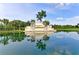 Elegant Heritage Harbour community entrance sign with palm trees reflecting in the water at 235 River Enclave Ct, Bradenton, FL 34212