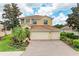 Two-story home featuring a tile roof, three-car garage, brick driveway, and professionally landscaped yard at 235 River Enclave Ct, Bradenton, FL 34212