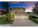 Two-story home showcases a red door, a three-car garage, and a well-manicured lawn at 235 River Enclave Ct, Bradenton, FL 34212