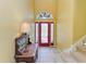 Inviting foyer area with glass door, tile flooring, a stained glass window and stairway at 235 River Enclave Ct, Bradenton, FL 34212