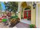 Inviting front entrance with a red double door, lush landscaping, and stone walkway at 235 River Enclave Ct, Bradenton, FL 34212