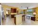Open kitchen features a breakfast bar, wood cabinets, stainless steel refrigerator, and views to the living area at 235 River Enclave Ct, Bradenton, FL 34212