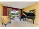 Bright living room with piano offering views of the pool and the lake beyond at 235 River Enclave Ct, Bradenton, FL 34212