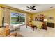 A sunlit living room features an inviting seating arrangement and access to the screened-in lanai and pool at 235 River Enclave Ct, Bradenton, FL 34212