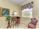 Cozy office area with a vintage desk, floral drapes and a decorative chair at 235 River Enclave Ct, Bradenton, FL 34212