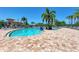 A sunny view of the community pool with palm trees and lounge chairs at 235 River Enclave Ct, Bradenton, FL 34212