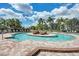 Community pool surrounded by brick and lush landscaping, a serene area for relaxation and enjoyment at 235 River Enclave Ct, Bradenton, FL 34212