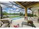 Covered patio with screened enclosure featuring a pool and spa with lake views at 235 River Enclave Ct, Bradenton, FL 34212