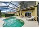 Backyard pool area featuring a screened enclosure, spa, and outdoor seating for lounging at 235 River Enclave Ct, Bradenton, FL 34212