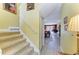 View of the staircase and hallway leading to the living room featuring tile floors and neutral walls at 235 River Enclave Ct, Bradenton, FL 34212