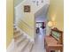 View of staircase from foyer area, and hallway leading to the living room with piano and tile floors at 235 River Enclave Ct, Bradenton, FL 34212