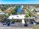 An aerial view of a waterfront community with lush landscaping, a canal, and a parking area at 2419 Riverbluff Pkwy # V233, Sarasota, FL 34231