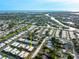 Aerial shot showcases a neighborhood with waterways, lush greenery, and clear blue skies at 2419 Riverbluff Pkwy # V233, Sarasota, FL 34231
