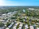 Aerial view of a community with homes nestled among trees near a river and bay area at 2419 Riverbluff Pkwy # V233, Sarasota, FL 34231
