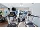 Exercise room featuring treadmills, bike, TV, ceiling fan, and sliding glass doors at 2419 Riverbluff Pkwy # V233, Sarasota, FL 34231