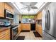 Well-lit kitchen with stainless steel appliances, tile floors, and a window with view of lush landscaping at 2419 Riverbluff Pkwy # V233, Sarasota, FL 34231