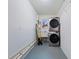 Functional laundry room with stacked washer and dryer, utility sink, and shelving at 2419 Riverbluff Pkwy # V233, Sarasota, FL 34231