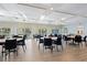 The meeting room has tables, chairs, ceiling fans, light wood floors, and views of the pool at 2419 Riverbluff Pkwy # V233, Sarasota, FL 34231