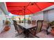 Inviting outdoor patio with a dining table, chairs, and a vibrant red umbrella at 2419 Riverbluff Pkwy # V233, Sarasota, FL 34231