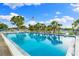 A gorgeous community pool with lounge chairs and an American flag with a blue sky and puffy clouds at 2419 Riverbluff Pkwy # V233, Sarasota, FL 34231