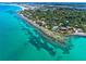 Stunning aerial shot of luxurious waterfront homes with pools and lush landscaping on clear turquoise water at 2419 Riverbluff Pkwy # V233, Sarasota, FL 34231