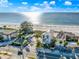 Aerial view showcasing beachfront homes, sandy beach, and blue ocean against a bright sky at 2500 Gulf N Dr, Bradenton Beach, FL 34217