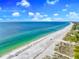Breathtaking aerial of the coastline with turquoise waters, white sand beach, and blue skies at 2500 Gulf N Dr, Bradenton Beach, FL 34217