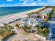 Coastal aerial view of beachfront homes, sandy beach, and blue ocean against a bright sky at 2500 Gulf N Dr, Bradenton Beach, FL 34217