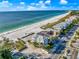 Coastal aerial view of beachfront homes, sandy beach, and blue ocean against a bright sky at 2500 Gulf N Dr, Bradenton Beach, FL 34217