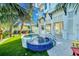 Backyard oasis featuring a swimming pool, a hot tub, ample seating, and lush tropical landscaping at 2500 Gulf N Dr, Bradenton Beach, FL 34217