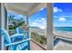 Balcony showcasing an outdoor kitchen, grill, and ocean views with light blue Adirondack chairs at 2500 Gulf N Dr, Bradenton Beach, FL 34217