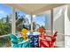 Colorful balcony setup with chairs and a table perfect for enjoying outdoor space and views at 2500 Gulf N Dr, Bradenton Beach, FL 34217
