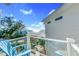 Beautiful balcony view of the ocean and sandy beach, with seating, blue chairs and privacy glass railing at 2500 Gulf N Dr, Bradenton Beach, FL 34217