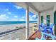 Relaxing balcony featuring ocean view, wood floors, and comfortable blue Adirondack chairs at 2500 Gulf N Dr, Bradenton Beach, FL 34217