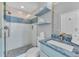 Charming bathroom featuring a glass-enclosed shower, decorative tile accents, and stylish blue vanity at 2500 Gulf N Dr, Bradenton Beach, FL 34217