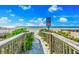 Picturesque beach access with wooden walkway and vibrant greenery leading to the beach at 2500 Gulf N Dr, Bradenton Beach, FL 34217