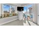 Bedroom featuring a window seat, TV, and sliding glass doors to a balcony with ocean views at 2500 Gulf N Dr, Bradenton Beach, FL 34217