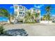 Beautiful beach house with a white exterior, multiple levels, and lush tropical landscaping at 2500 Gulf N Dr, Bradenton Beach, FL 34217