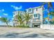 Beautiful beach house with a white exterior, multiple levels, and lush tropical landscaping at 2500 Gulf N Dr, Bradenton Beach, FL 34217