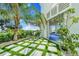 Landscaped front yard with pavers and lush foliage, complemented by views of beach houses and palm trees at 2500 Gulf N Dr, Bradenton Beach, FL 34217