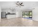 Open-concept living room featuring tile flooring, a ceiling fan, and sliding glass doors to the patio at 2575 Johannesberg Rd, North Port, FL 34288