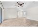 Minimalist living room showcasing tile floors, a ceiling fan, and a door leading to an adjacent room at 2575 Johannesberg Rd, North Port, FL 34288